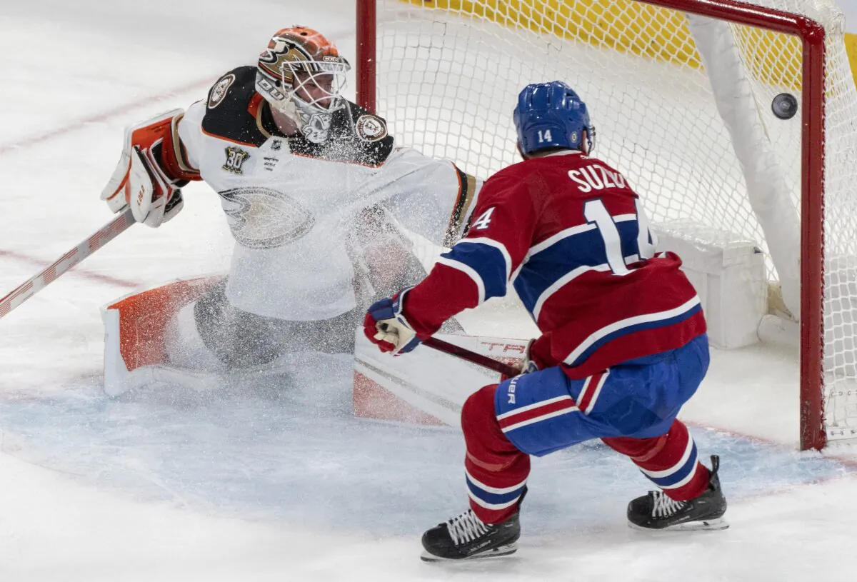 Montreal Canadiens' Nick Suzuki (14) scores on Anaheim Ducks goaltender Lukas Dostal (1) during the second period of an NHL game in Montreal on Feb. 13, 2024. (Christinne Muschi/The Canadian Press via AP)