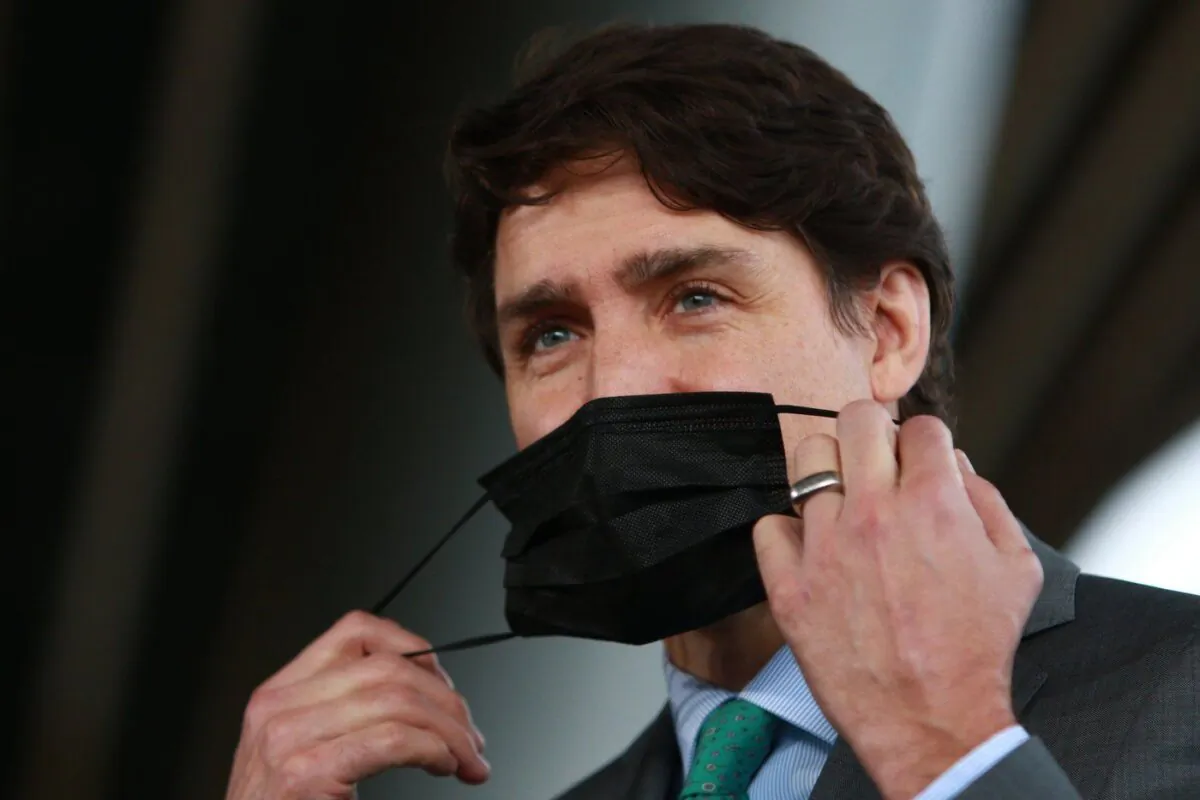 Prime Minister Justin Trudeau removes his protective mask to answer a question during a press conference outside the GLOBE Forum at the Convention Centre in Vancouver, B.C., on Mar. 29, 2022. (The Canadian Press/Chad Hipolito)
