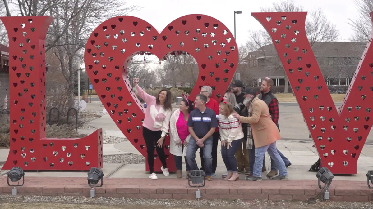 Volunteers pose for a photo in front of a “Love” art installation at the visitors center in Loveland, Colo., on Feb. 7, 2024. (Thomas Peipert/AP Photo)