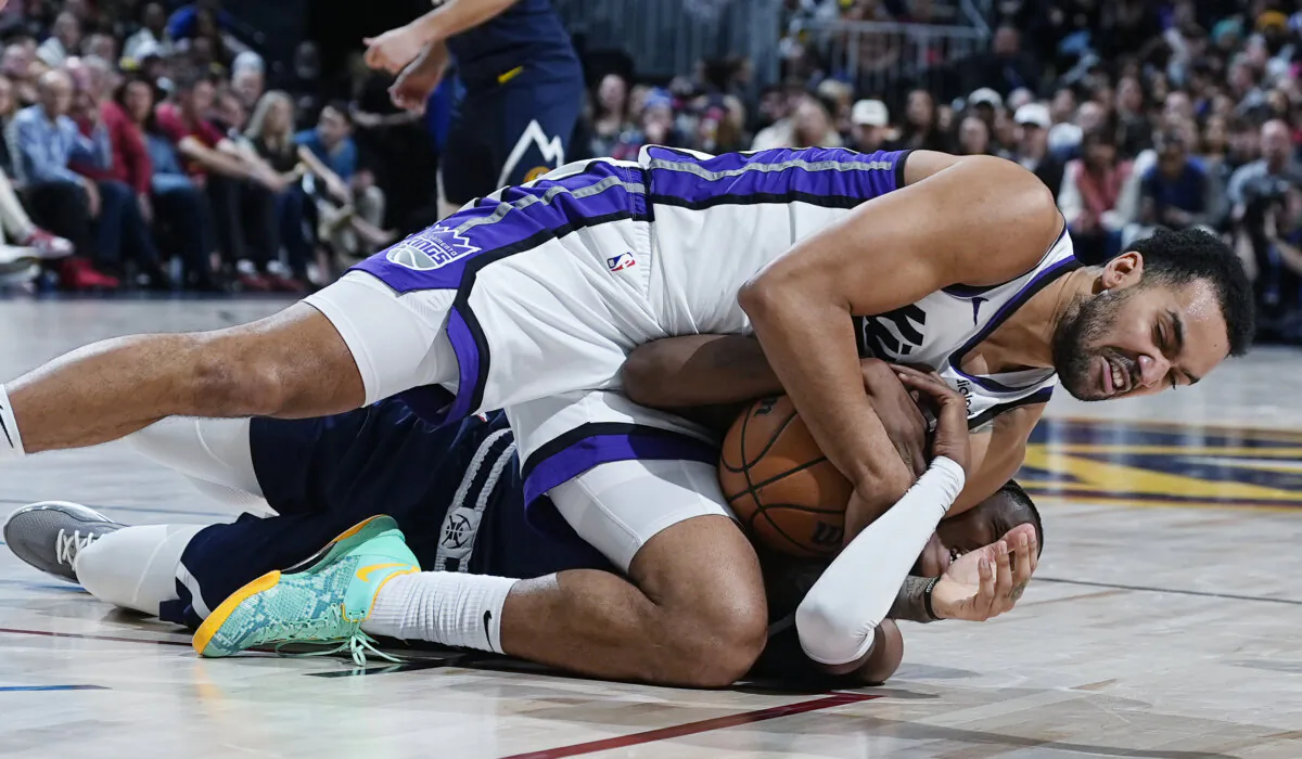 Sacramento Kings forward Trey Lyles, top, fights for control of a loose ball with Denver Nuggets forward Peyton Watson in the second half of an NBA basketball game in Denver on Feb. 14, 2024. (David Zalubowski/AP Photo)