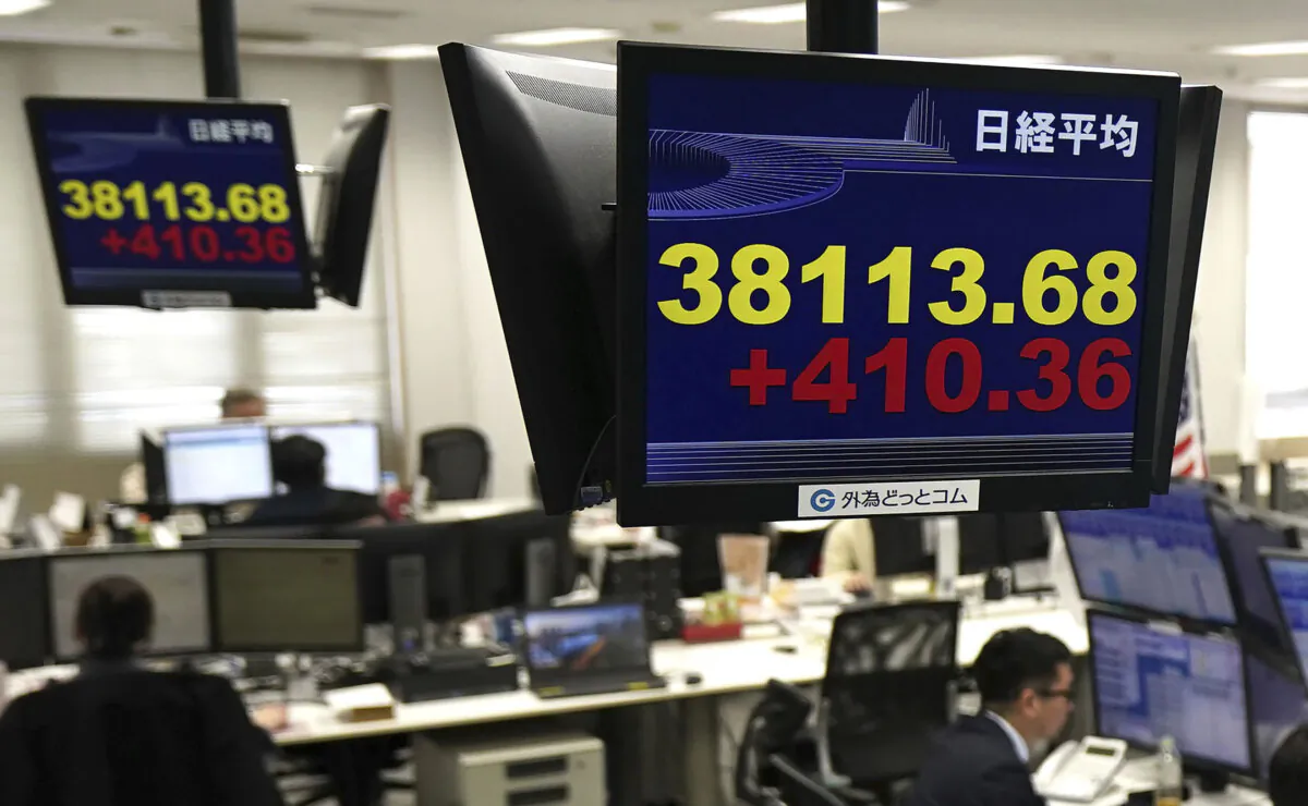 Monitors show Nikkei stock index, yellow, at a foreign exchange trader's company in Tokyo, on Feb. 15, 2024. (Kyodo News via AP)