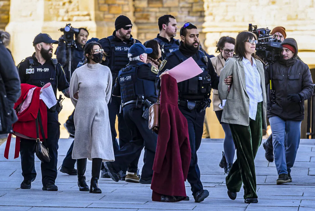 Pro-Palestine protesters who disrupted question period in the House of Commons are led away by Parliamentary Protective Service officers outside West Block on Parliament Hill in Ottawa, on Feb. 14, 2024. (The Canadian Press/Justin Tang)