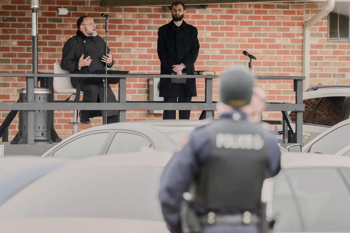 An Aylmer police officer videotapes as Pastor Henry Hildebrandt speaks during a drive-in service at The Church of God in Aylmer, Ont. on Sunday, April 26, 2020. Police monitored the service after complaints about the church’s social distancing measures at their drive-in service last week.
THE CANADIAN PRESS/Geoff Robins