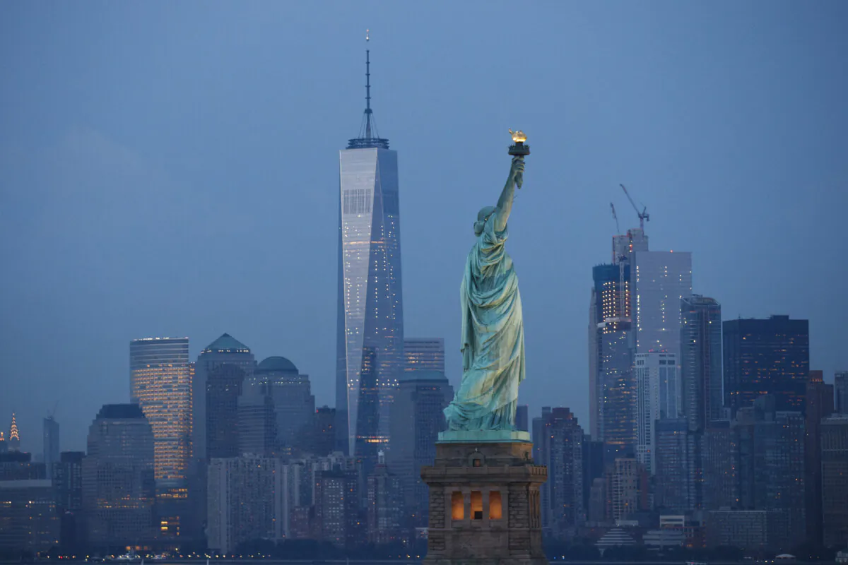 The Statue of Liberty stands in the foreground as Lower Manhattan is viewed at dusk in New York City on Sep. 8, 2016. (Drew Angerer/Getty Images)