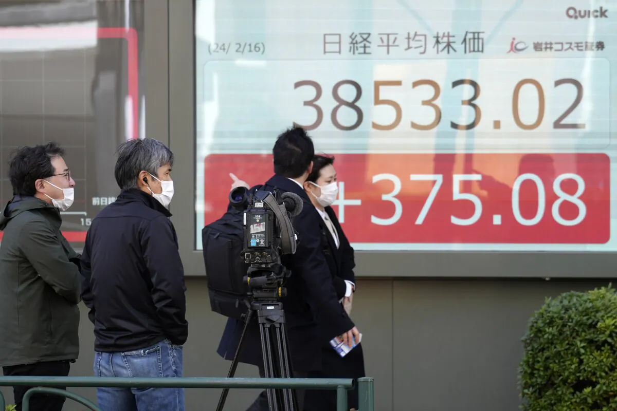 TV crew members film an electronic stock board showing Japan's Nikkei 225 index at a securities firm as people pass by, in Tokyo on Feb. 16, 2024. (Eugene Hoshiko/AP Photo)