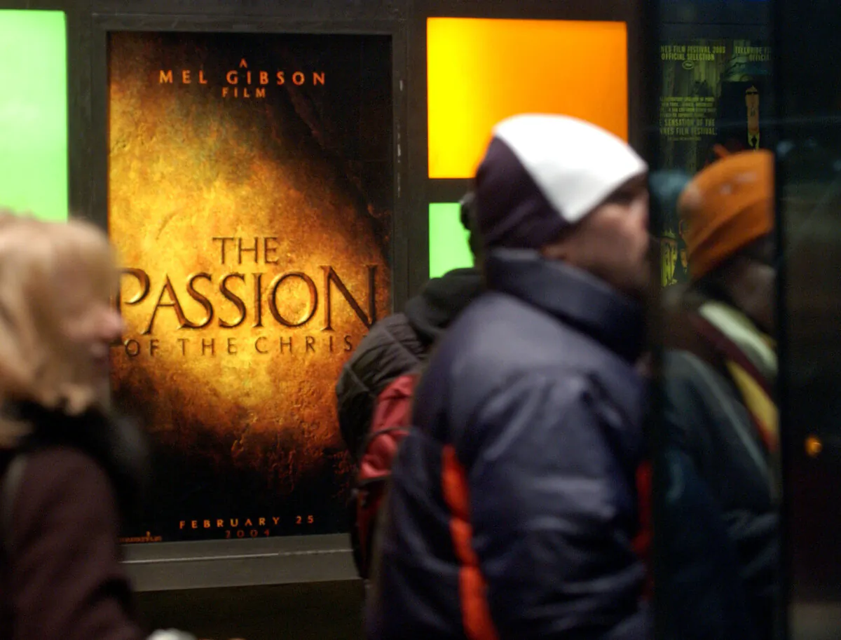 Movie-goers wait in line in front of an advertisement for Mel Gibson's "The Passion of the Christ" at a theater in New York City, on Feb. 25, 2004. (Stephen Chernin/Getty Images)