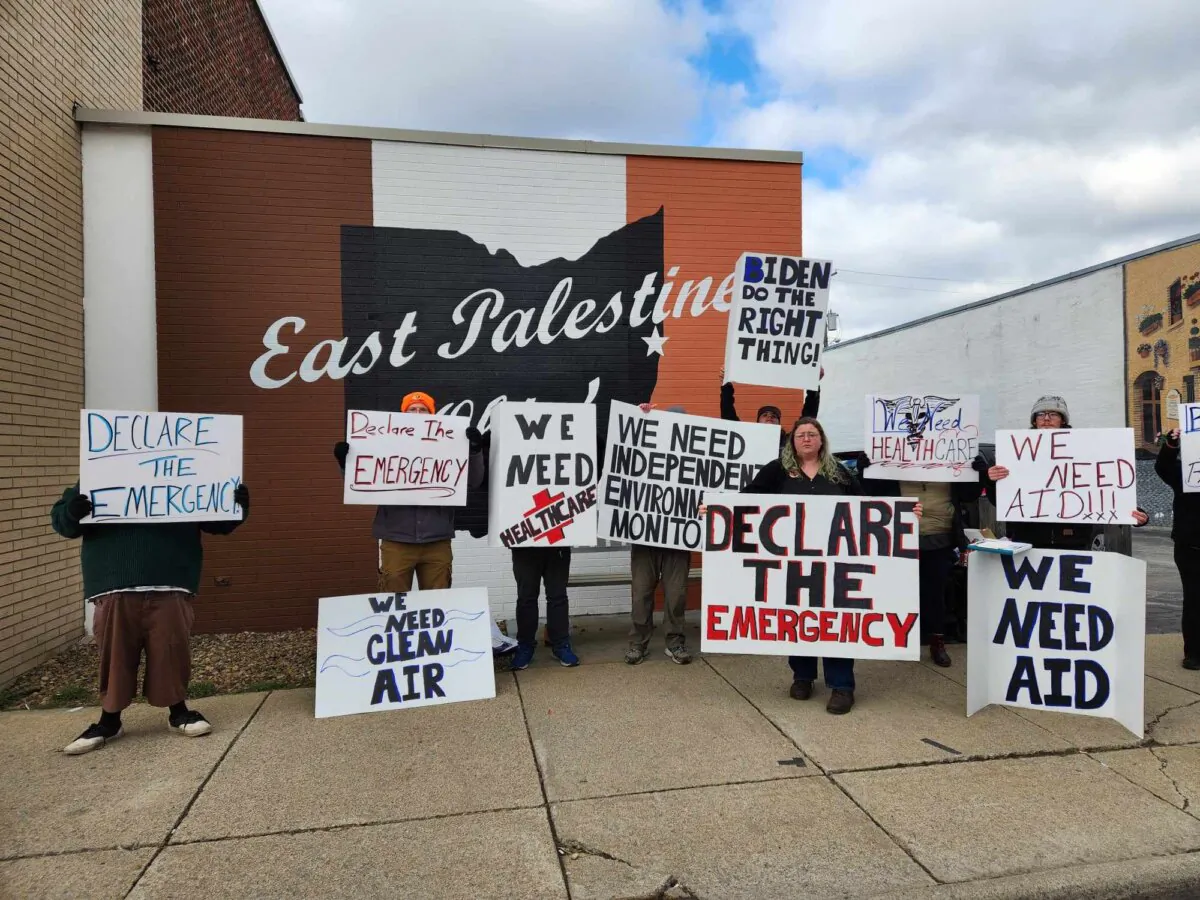 Members of a nonprofit organization working to improve environmental and health conditions in East Palestine demonstrate before President Joe Biden's visit on Feb. 16, 2024. (Jeff Louderback/The Epoch Times)