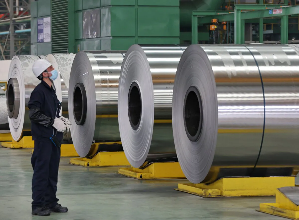 An employee examines steel rolls at a factory in Nantong, Jiangsu province, China, on March 1, 2022. (STR/AFP via Getty Images)