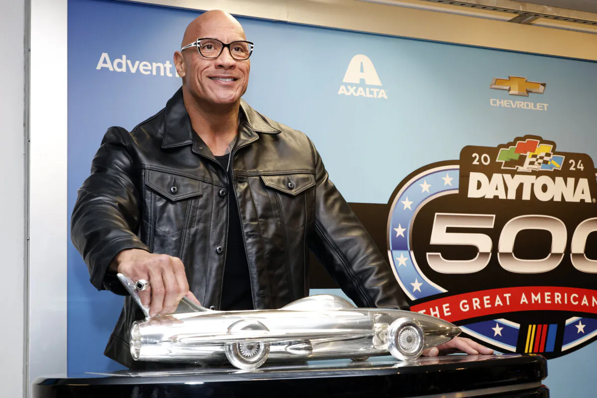 Grand Marshal Dwayne "The Rock" Johnson poses with the Harley J. Earl trophy after the NASCAR Daytona 500 auto race was postponed by rain, at Daytona International Speedway in Daytona Beach, Fla., on Feb. 18, 2024. (AP Photo/Terry Renna)