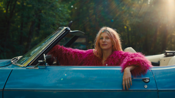 woman in pink coat in blue car in MARMALADE