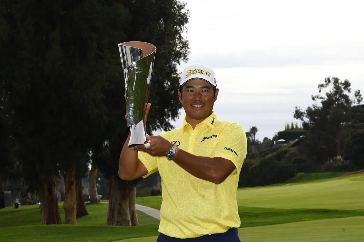 Hideki Matsuyama of Japan poses for a photo with the trophy after putting in to win on the 18th green during the final round of The Genesis Invitational at Riviera Country Club in Pacific Palisades, Calif., on Feb. 18, 2024. (Ronald Martinez/Getty Images)