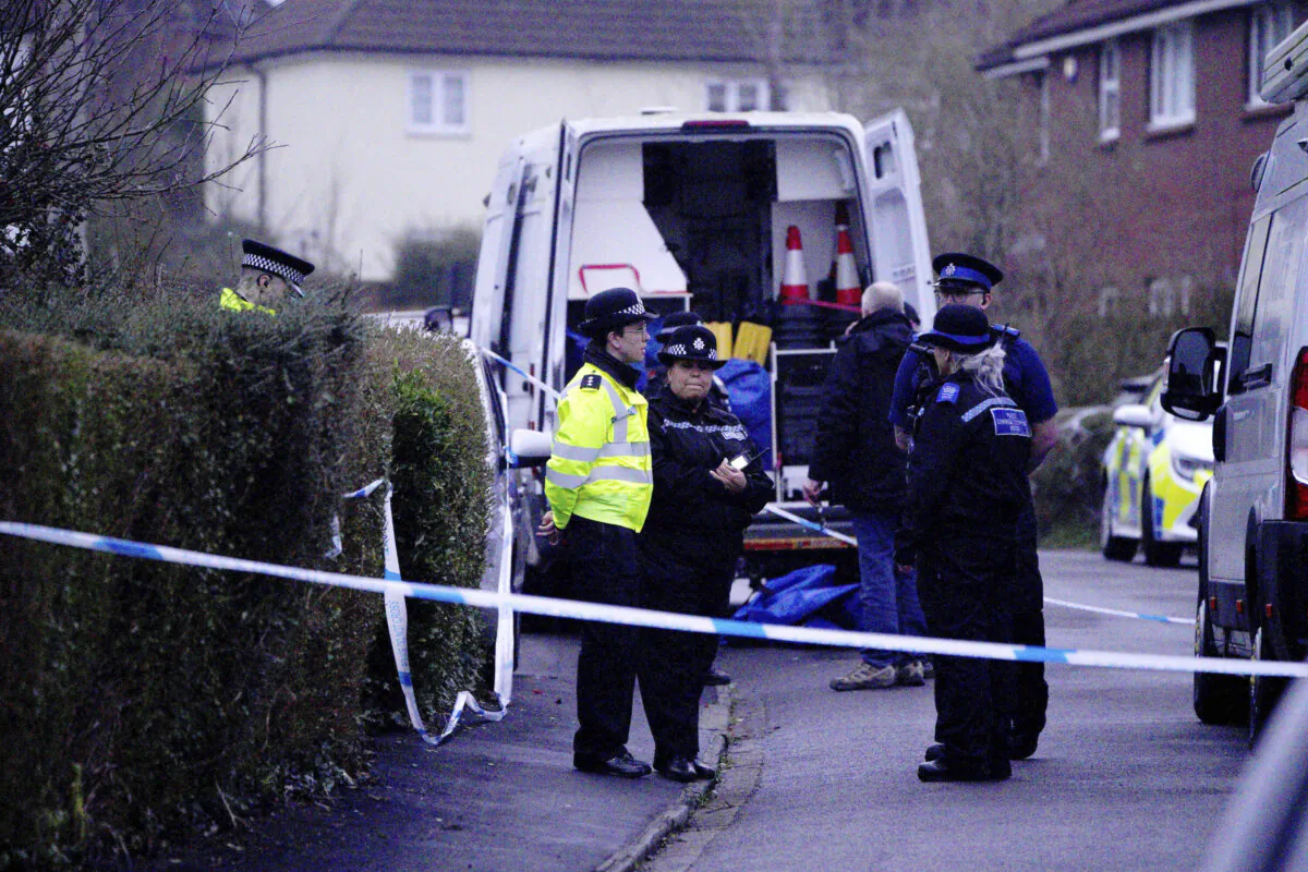 Police work at the scene in Blaise Walk, in Sea Mills, Bristol, England, where a woman has been arrested on suspicion of murder after three children were found dead at a property, on Feb. 18, 2024. (Ben Birchal/PA via AP)