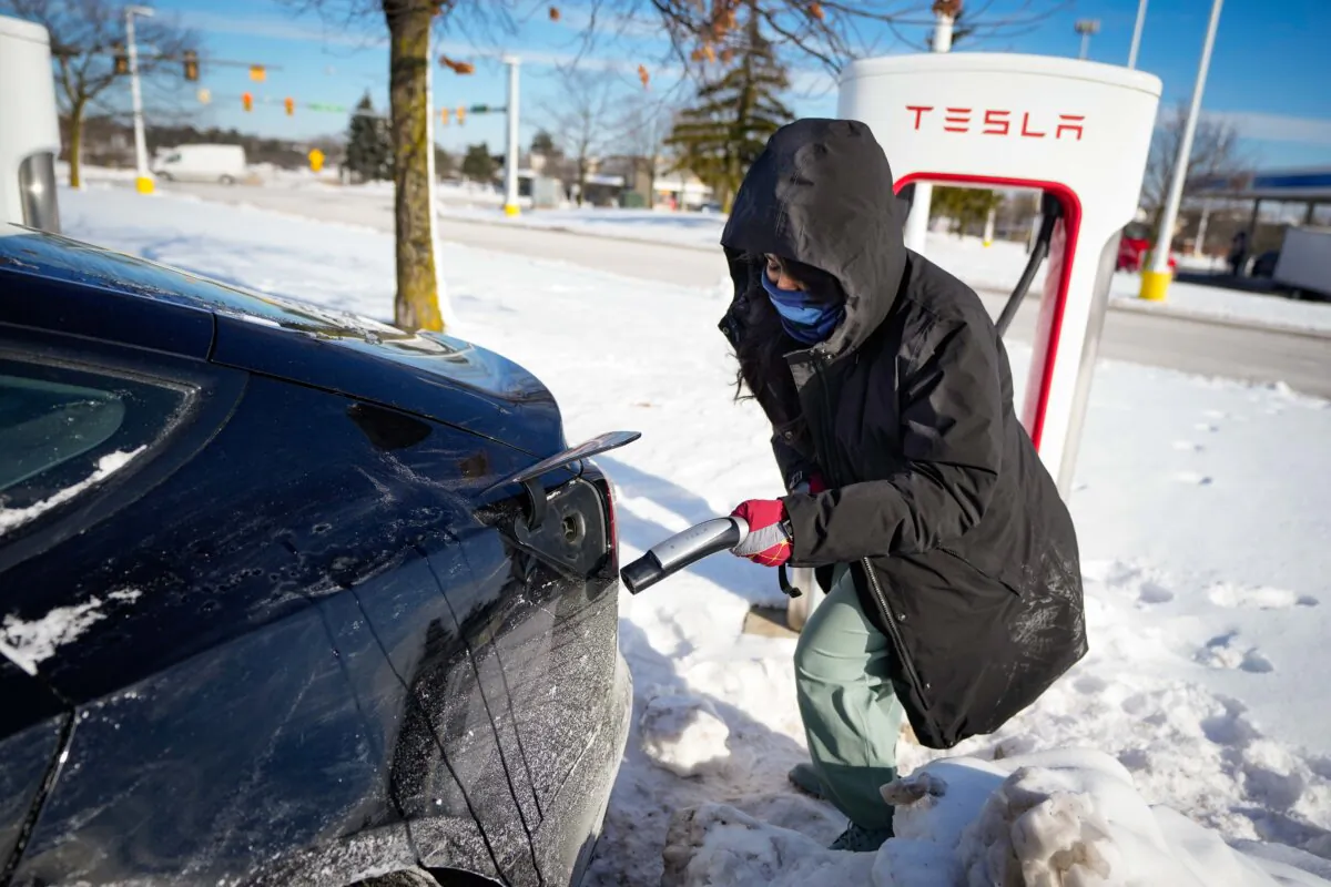 A woman prepares to charge her Tesla in Ann Arbor, Mich., on Jan. 17, 2024. A cold snap across the United States and Canada has exposed a big vulnerability for electric vehicle owners. (AP Photo/Carlos Osorio)