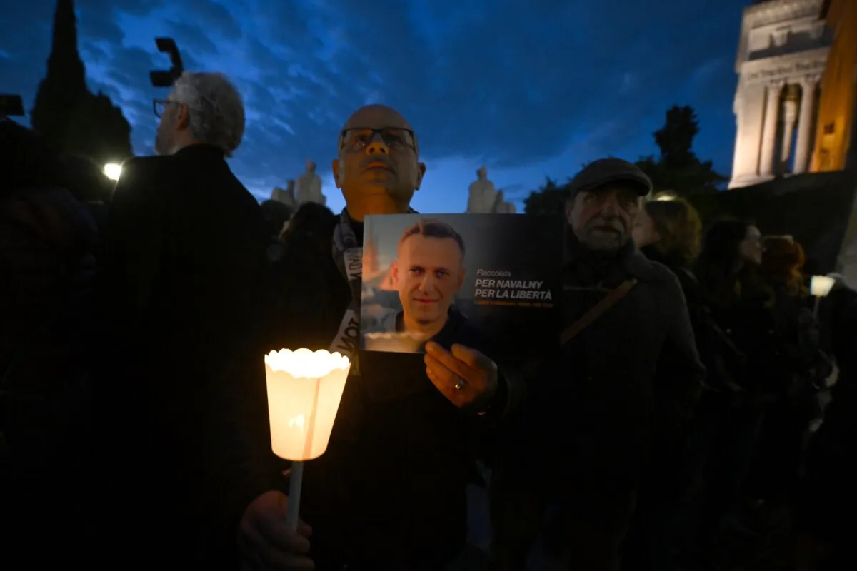 A man holds a portrait of Kremlin critic Alexei Navalny during a vigil at Rome's city hall, on Feb. 19, 2024. (Filippo Monteforte/AFP via Getty Images)