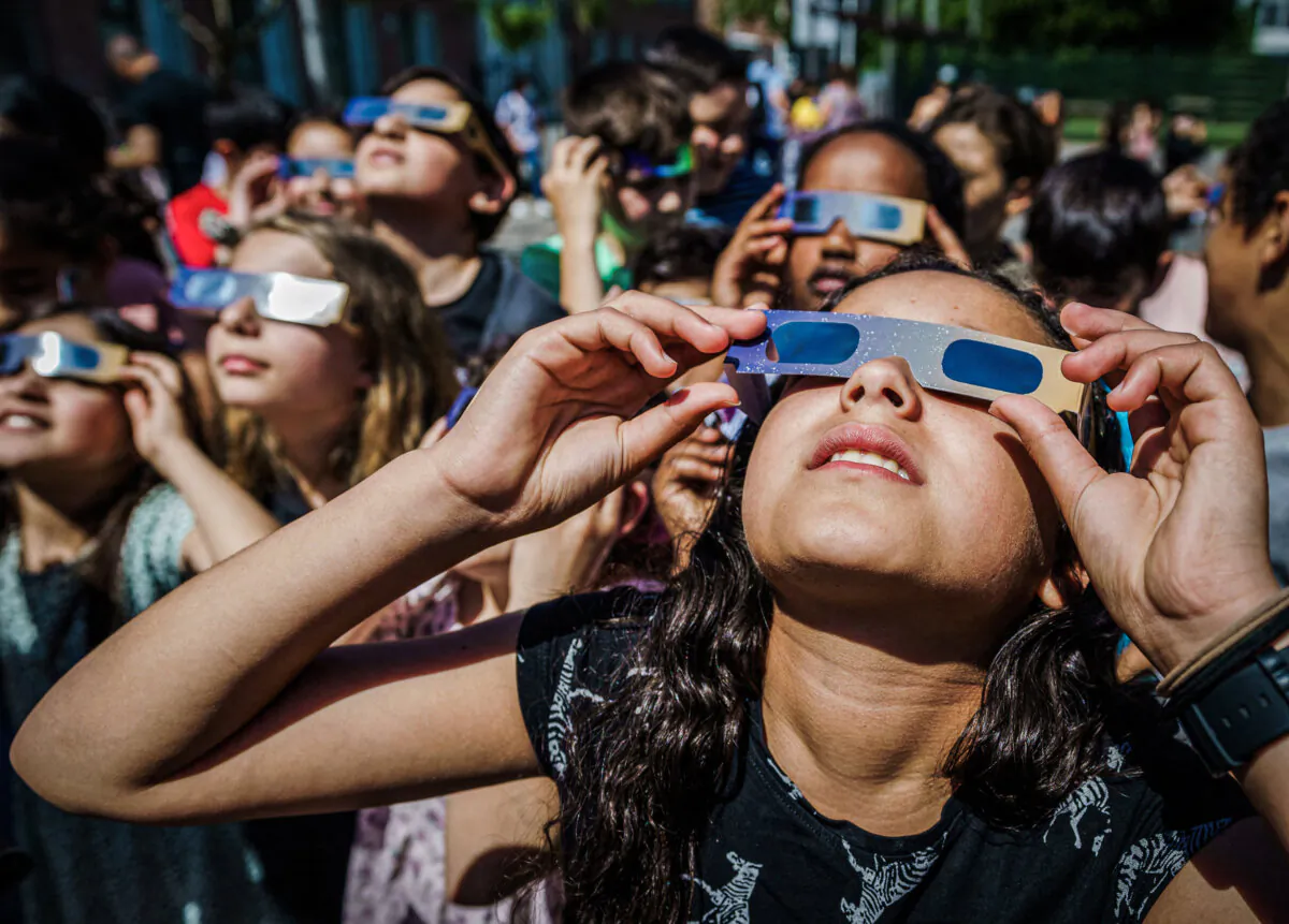 Pupils, wearing protective glasses, look at the partial solar eclipse in Schiedam, Netherlands, on June 10, 2021. (Marco de Swart/ANP/AFP via Getty Images)