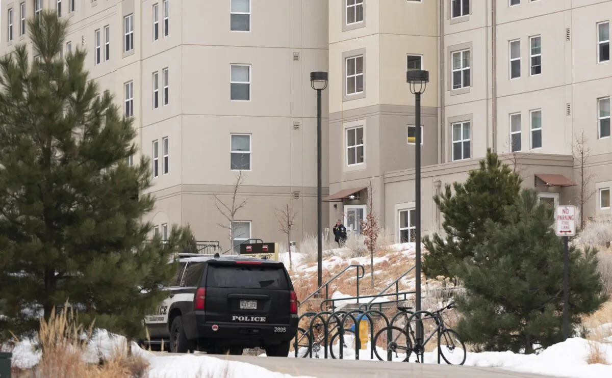 A police officer stands outside a dorm in the Village at Alpine Valley housing in Colorado Springs, Colo., on Feb. 16, 2024, as police investigate a shooting on the University of Colorado Colorado Springs campus. (Christian Murdock/The Gazette via AP)
