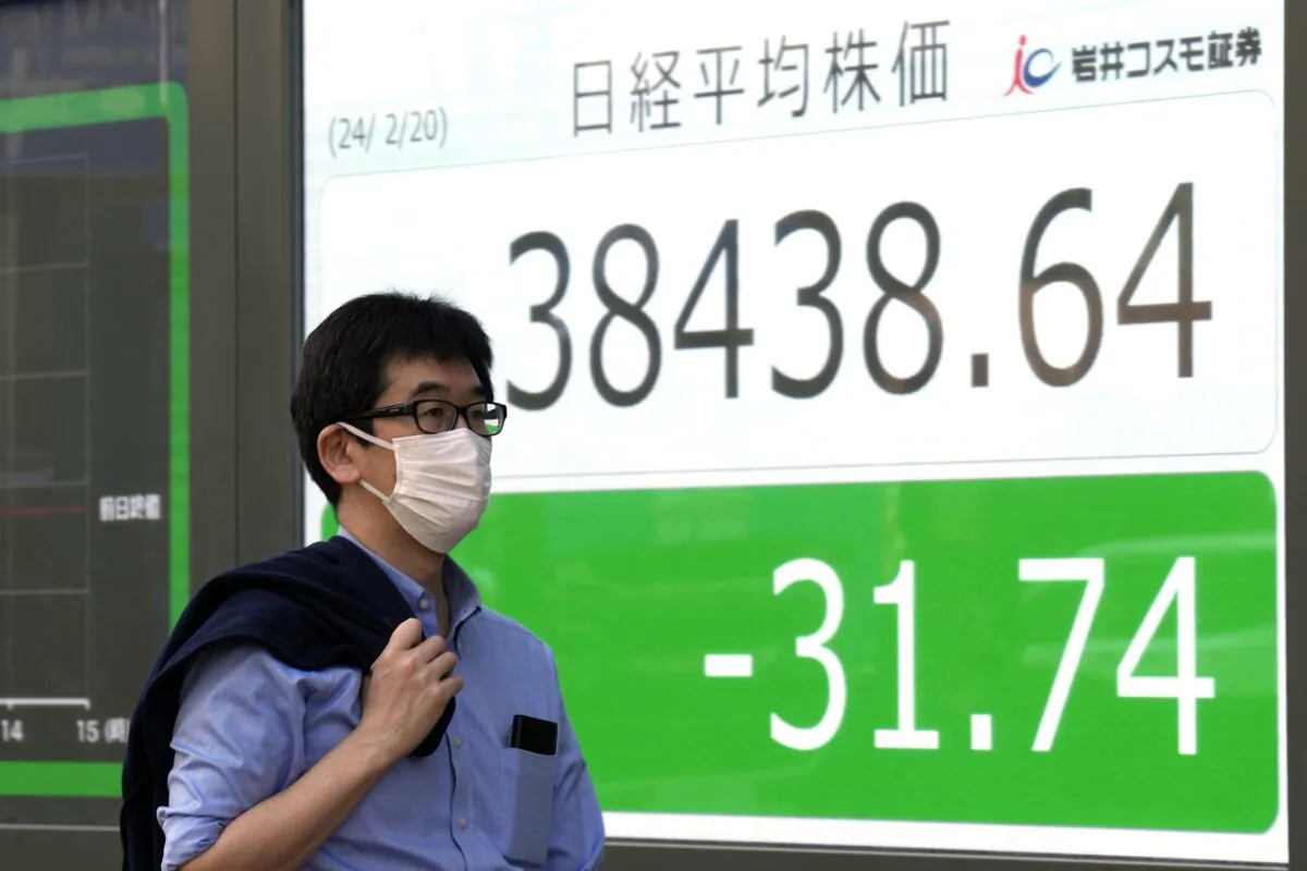 A person walks in front of an electronic stock board showing Japan's Nikkei index at a securities firm in Tokyo on Feb. 20, 2024. (Eugene Hoshiko/AP Photo)