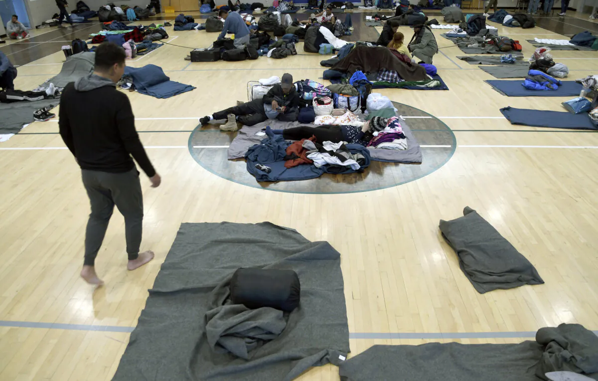 Migrants rest at a makeshift shelter in Denver on Jan. 6, 2023. Over the past month, nearly 4,000 immigrants, almost all Venezuelans, have arrived unannounced in the frigid city, with nowhere to stay and sometimes wearing T-shirts and flip-flops. In response, Denver converted three recreation centers into emergency shelters for migrants and paid for families with children to stay at hotels, allocating $3 million to deal with the influx. (Thomas Peipert/AP Photo)