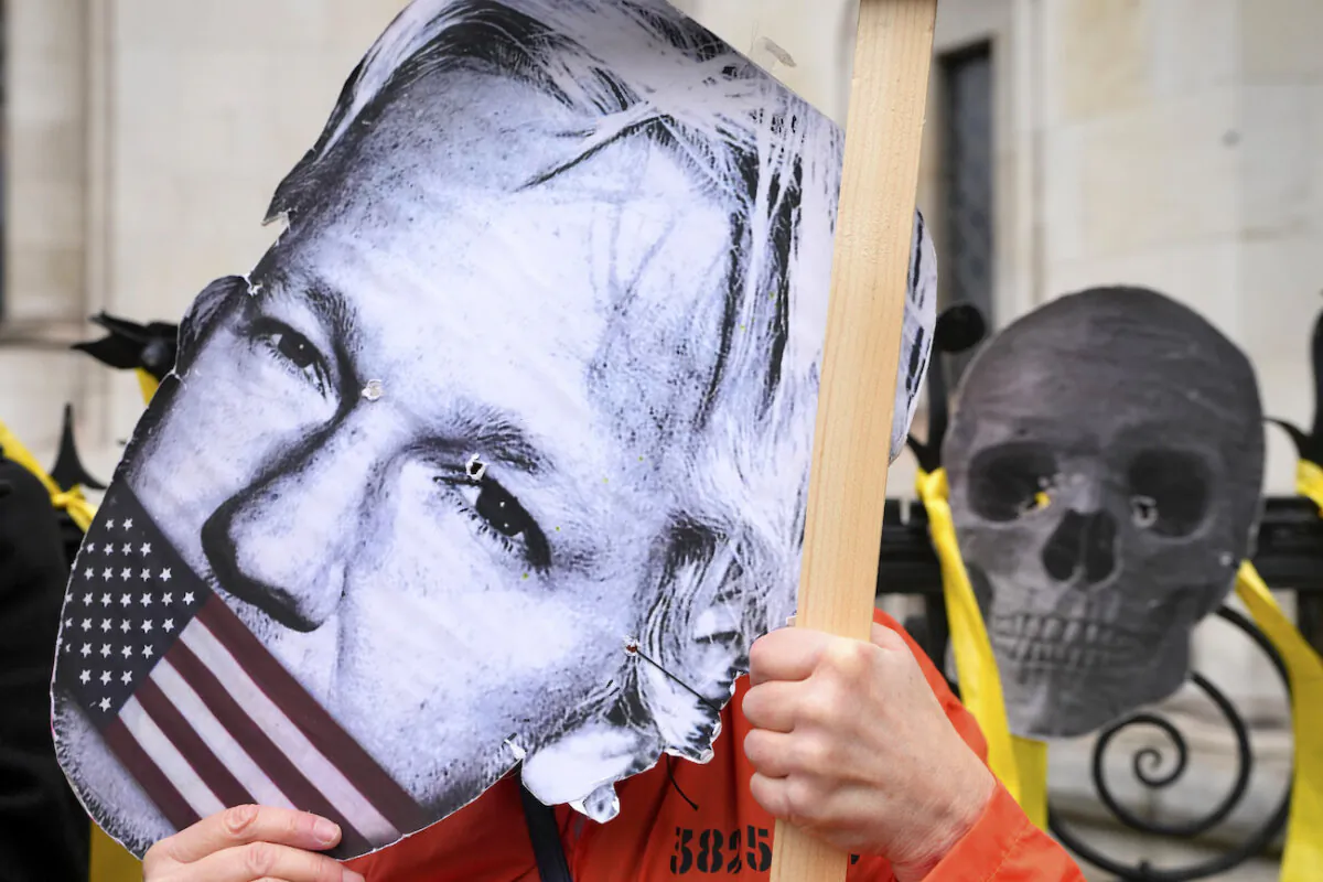 A demonstrator holds a Julian Assange mask outside the Royal Courts of Justice in London, on Feb. 20, 2024. (Kirsty Wigglesworth/AP Photo)