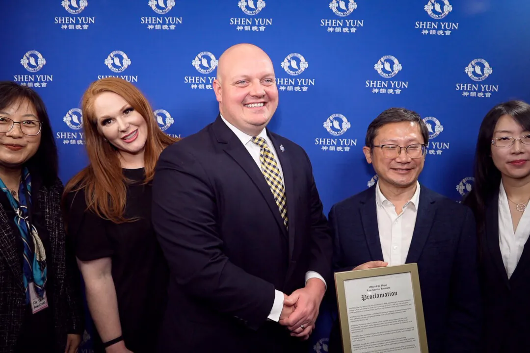 Mayor Nic Hunter (center) presenting a proclamation to the local hosts of Shen Yun Performing Arts at the Rosa Hart Theater on Feb. 20, 2024. (NTD)
