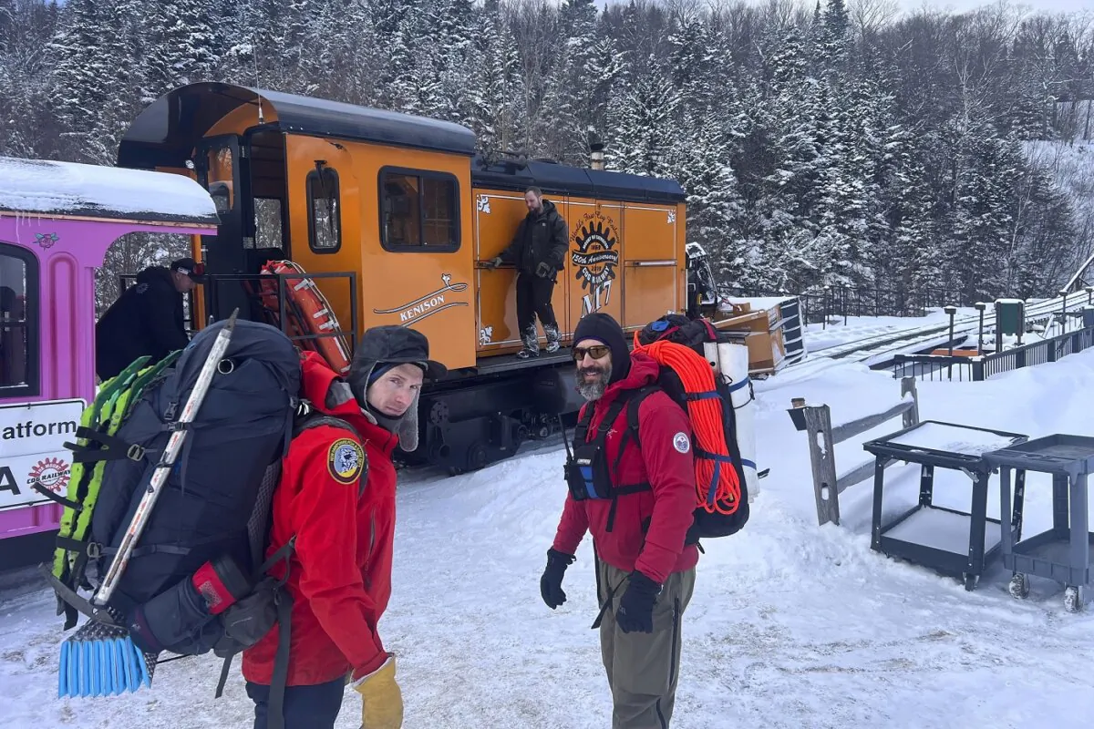 New Hampshire Fish and Game conservation officer Levi Frye (L) and Jeremy Broughton, from Androscoggin Valley Search and Rescue, prepare to head out on a rescue mission at the Cog Railway base station in Mount Washington, N.H., on Feb. 17, 2024. (Sgt. Glen Lucas/New Hampshire Fish and Game via AP)