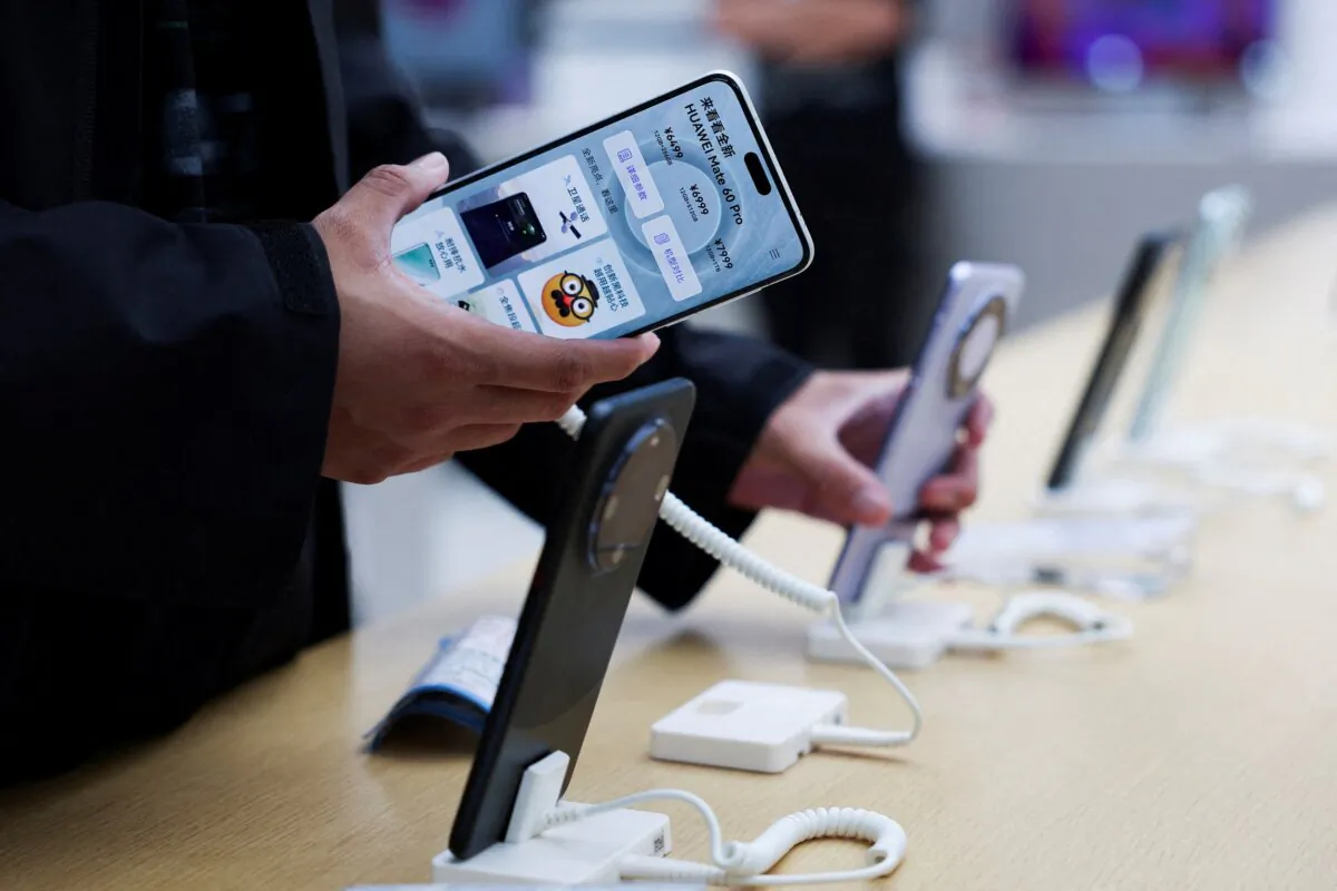 A person checks a Huawei Mate 60 Pro smartphone displayed at a Huawei flagship store in Beijing on Sept. 25, 2023. (Florence Lo/Reuters)