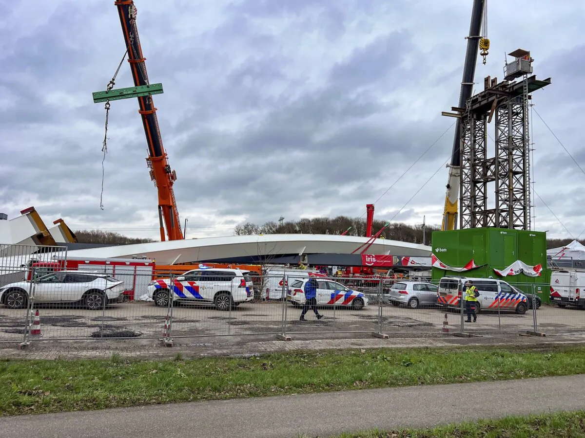 Emergency workers and police stand at the site where two people died and two more were injured in Lochem, easter Netherlands, on Feb. 21, 2024, when part of a new bridge being built over a canal collapsed, emergency services said. (Rens Hulman/AP Photo)