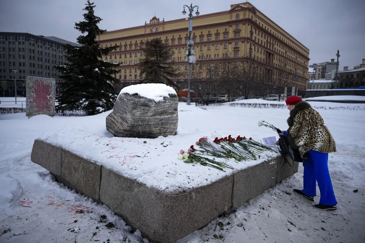 Woman lay flowers to pay tribute to Alexei Navalny at a monument outside the historical Federal Security Service building in Moscow, on Feb. 21, 2024. (The Canadian Press/AP-Alexander Zemlianichenko)