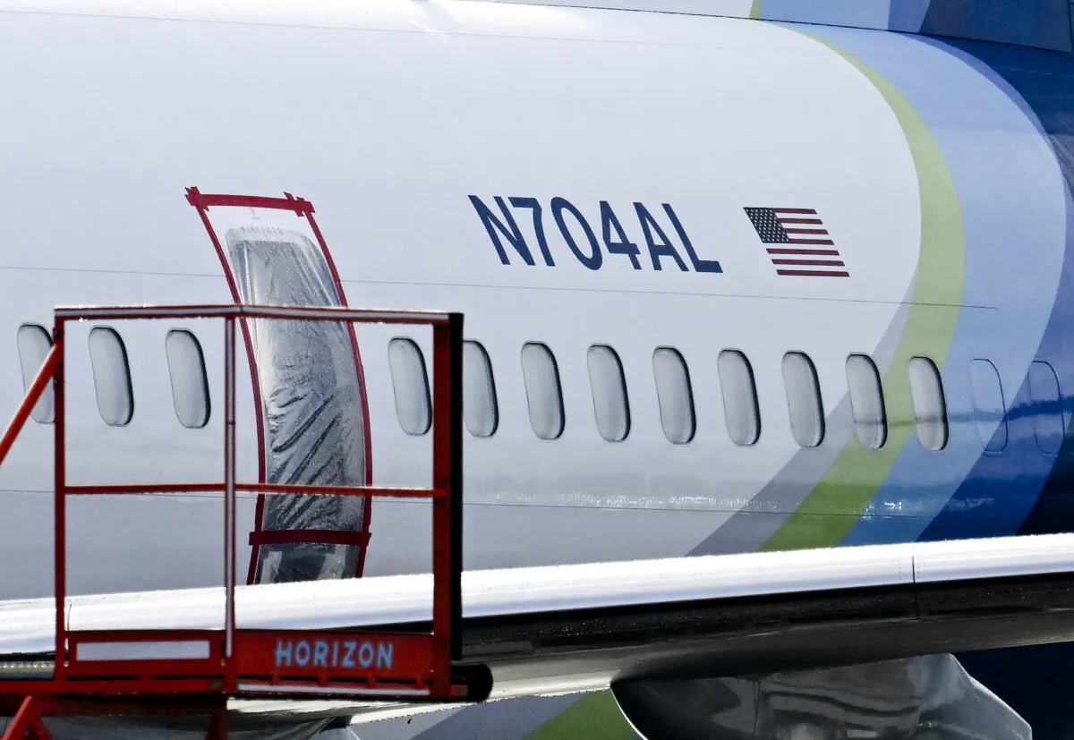 The missing emergency door of an Alaska Airlines 737 Max, which made an emergency landing due to a door plug blowout, is covered and taped, in Portland, Ore., on Jan. 23, 2024. (Patrick T. Fallon / AFP)