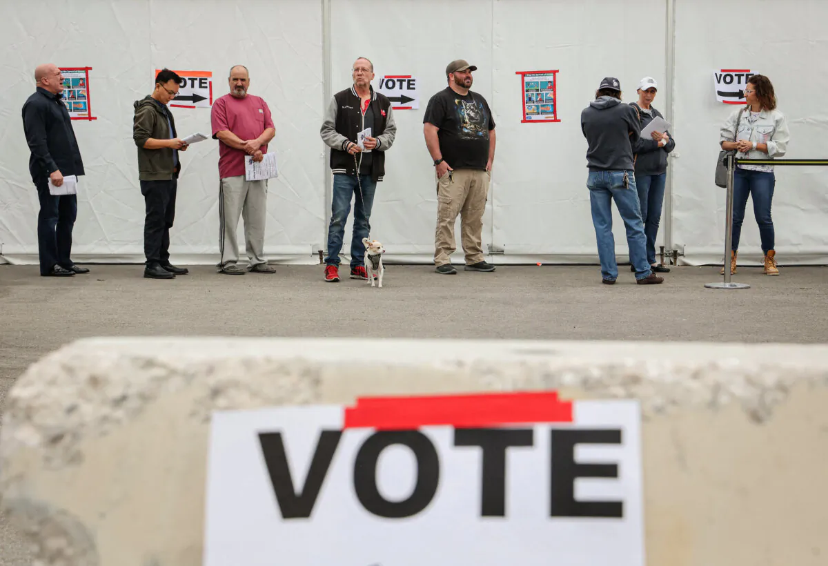 Campaign signs are shown near voters waiting in line at Las Vegas Athletic Club poling station on Election Day in Las Vegas on Nov. 8, 2022. (Ronda Churchill/Getty Images)