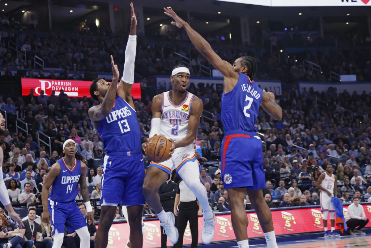 Oklahoma City Thunder guard Shai Gilgeous-Alexander (C) looks to pass the ball between Los Angeles Clippers forwards Paul George (13) and Kawhi Leonard (2) during the first half of an NBA basketball game in Oklahoma City on Feb. 22, 2024. (Nate Billings/AP Photo)
