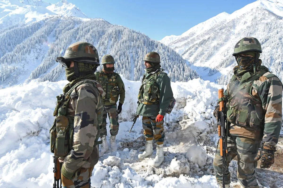 Indian army soldiers stand on a snow-covered road near Zojila mountain pass that connects Srinagar to the union territory of Ladakh, bordering China, on Feb. 28, 2021. (Tauseef Mustafa/AFP via Getty Images)