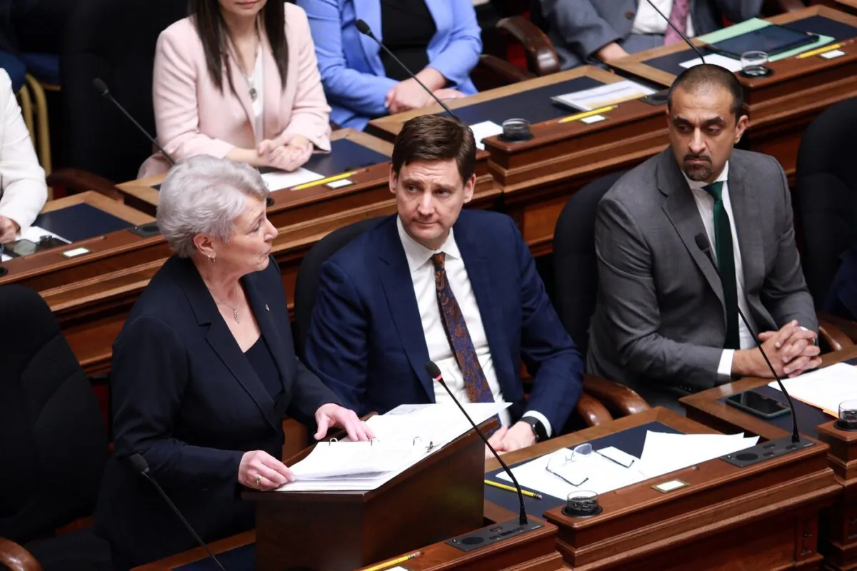 Finance Minister Katrine Conroy tables the budget as Premier David Eby and housing minister Ravi Kahlon look from the legislative assembly at the legislature in Victoria, on Feb. 22, 2024. (The Canadian Press/Chad Hipolito)