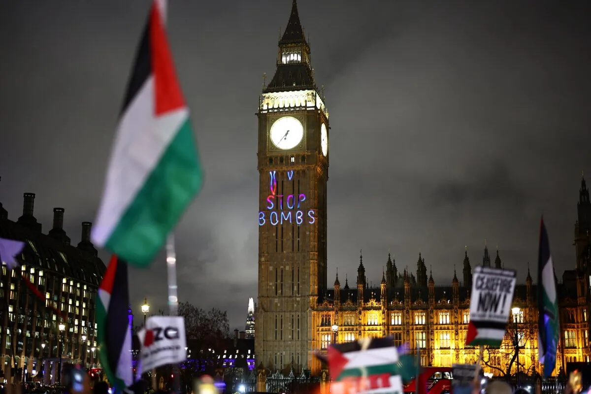 A Palestinian flag flaps in the air by a message reading 'Stop bombs' projected on The Elizabeth Tower at the Palace of Westminster, home to the Houses of Parliament, during a Pro-Palestinian demonstration in Parliament Square in London on Feb. 21, 2024. (Henry Nicholls/AFP via Getty Images)