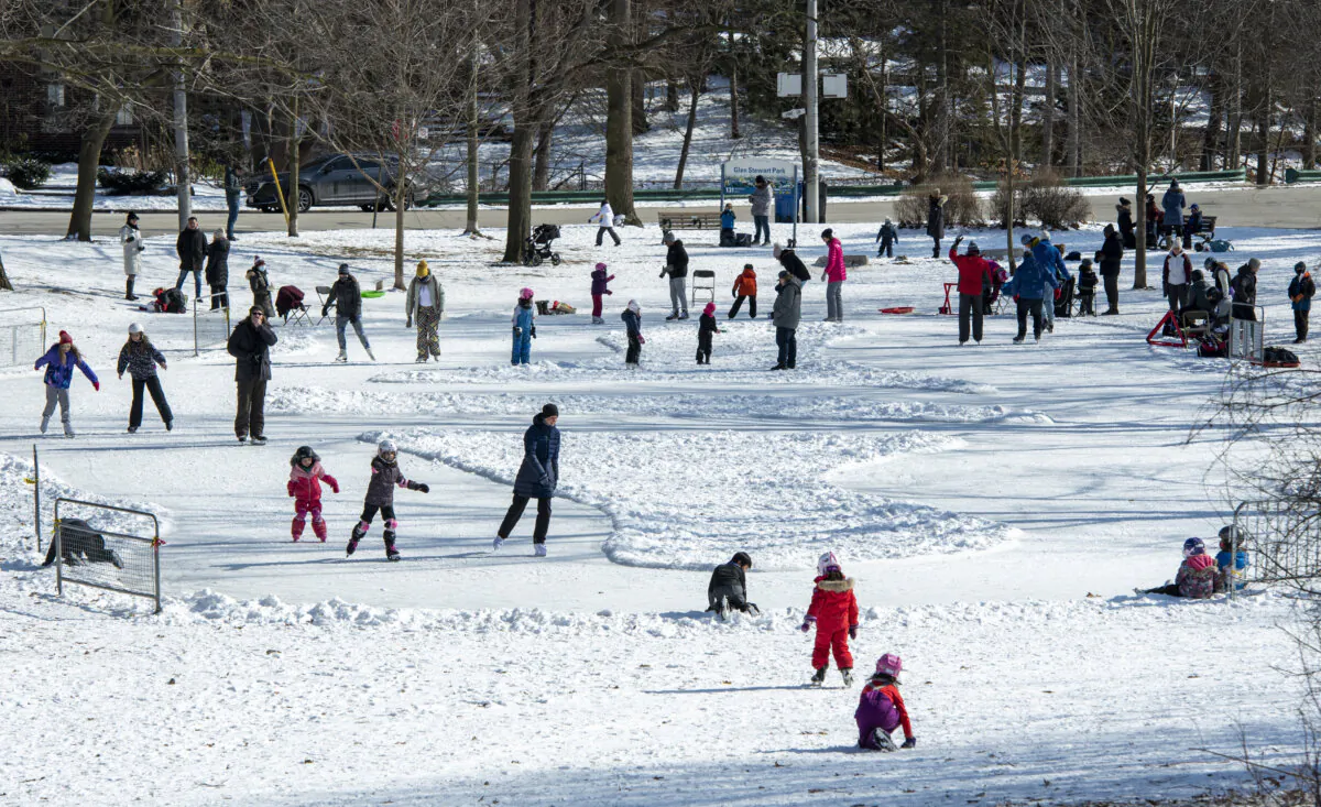 Parents and children enjoy Family Day as they skate on a home-made ice rink in a city park in Toronto on Feb. 15, 2021. (The Canadian Press/Frank Gunn) 