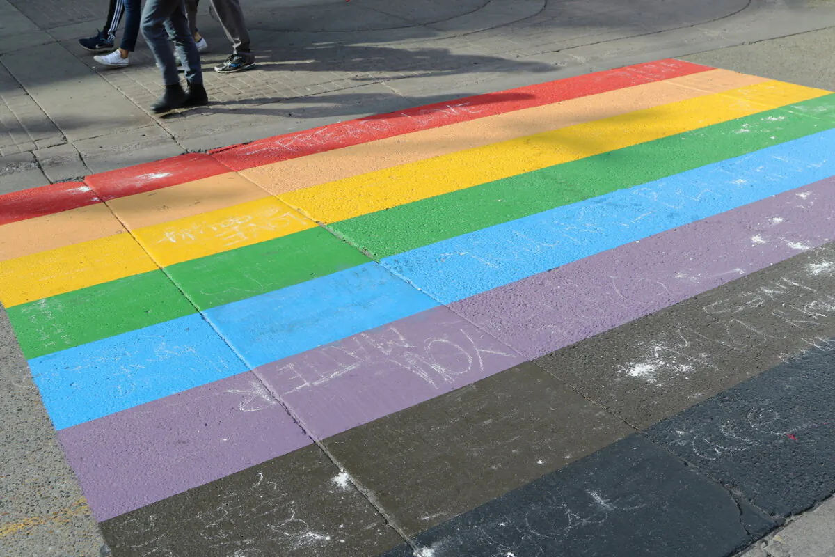 People walk past a Pride flag crosswalk in Calgary on Aug. 18, 2019. (The Canadian Press/Dave Chidley)