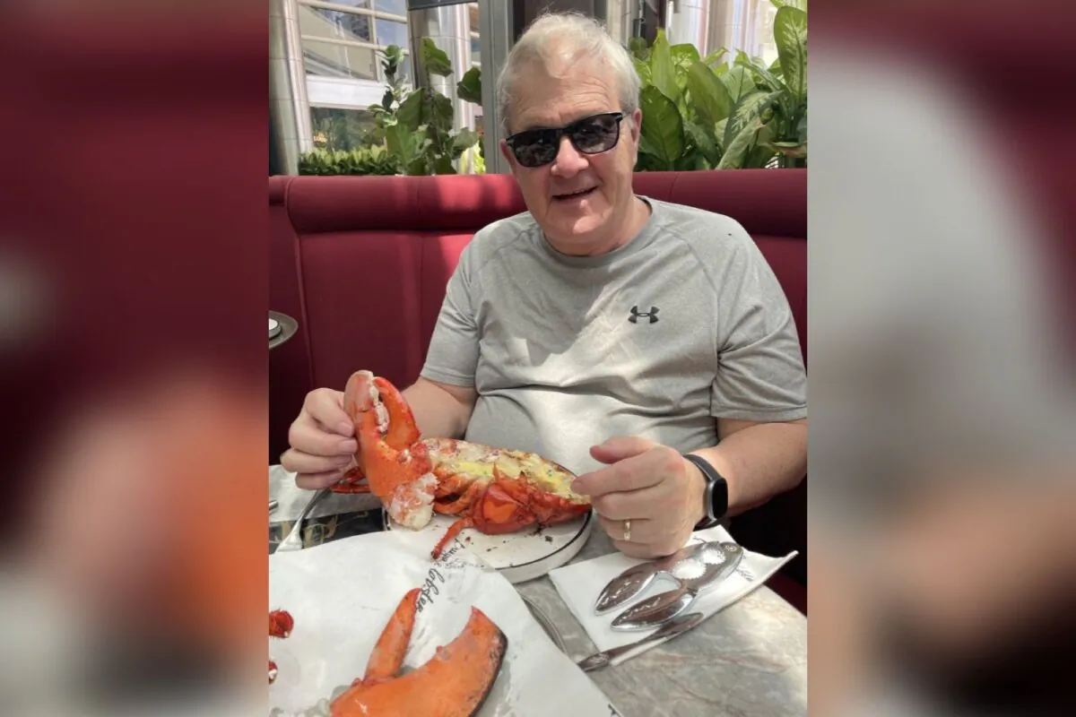 A social media post  on the X platform shows a sun-dappled Lawrence MacAulay looking relaxed in a grey T-shirt wearing sunglasses, holding a lobster claw in his right hand. (The Canadian Press/HO-X-@L_MacAulay)
