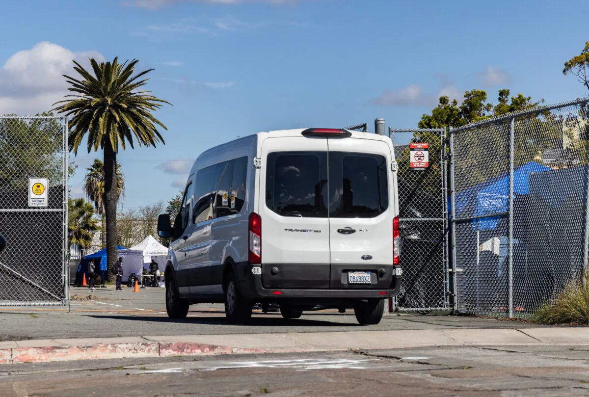 A van holding illegal immigrants drives into a school being used to shelter migrants in San Diego, Calif., on Feb. 22, 2024. (John Fredricks/The Epoch Times)