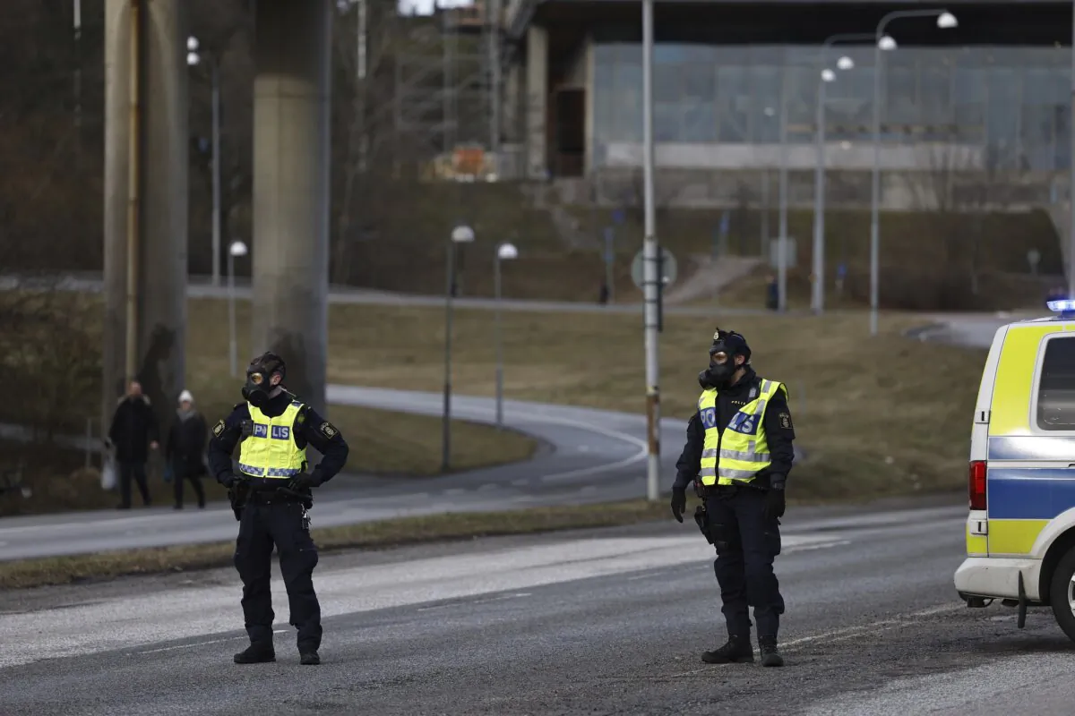 Police officers with gas masks stand guard near the Security Police's headquarters in Solna, north of Stockholm, on Feb. 23, 2024. (Fredrik Persson/TT News Agency via AP)