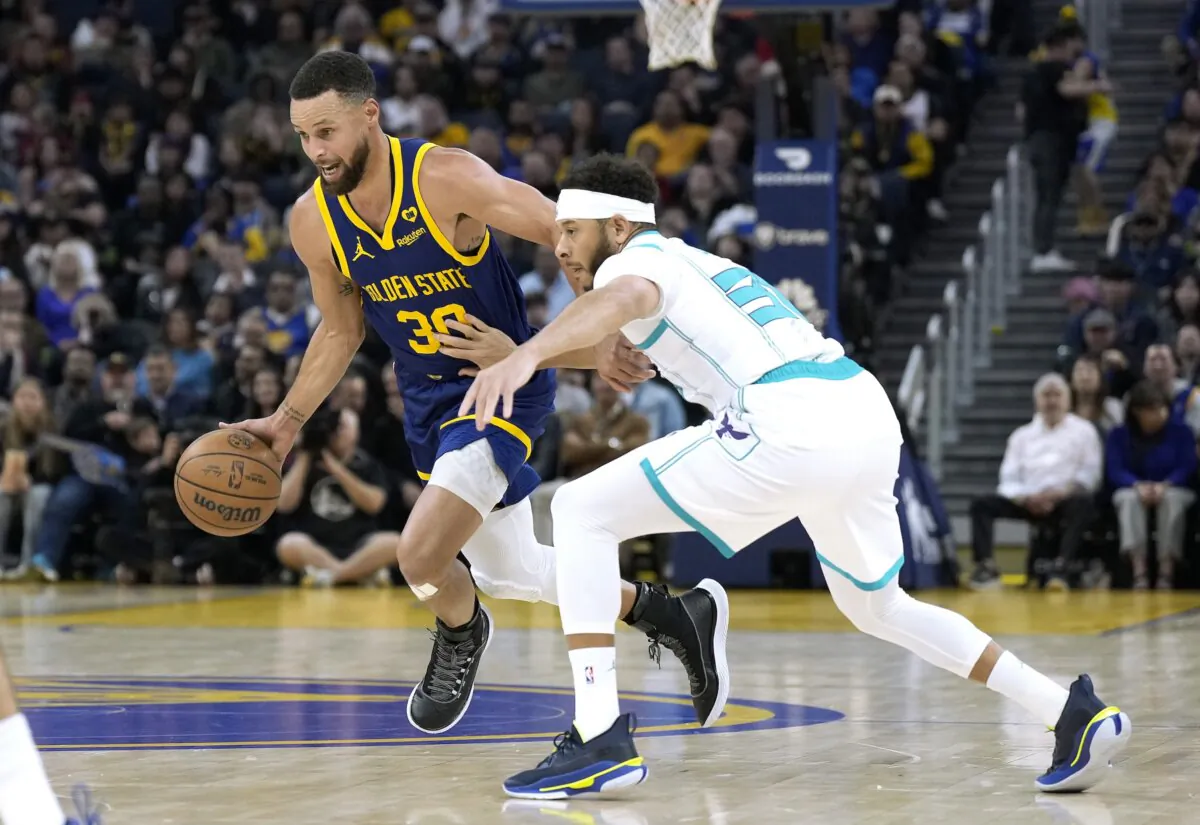 Stephen Curry (30) of the Golden State Warriors drives towards the basket dribbling past Seth Curry (30) of the Charlotte Hornets in the first quarter in San Francisco on Feb. 23, 2024. (Thearon W. Henderson/Getty Images)