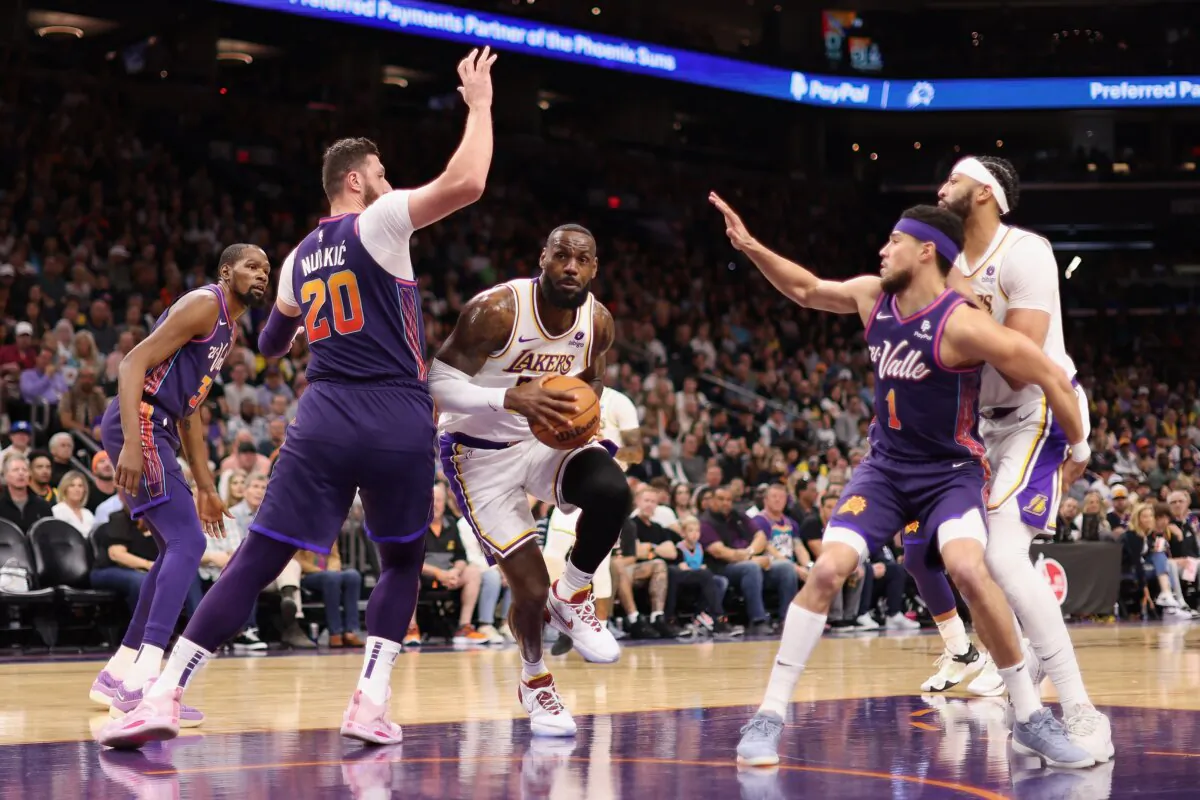 LeBron James (23) of the Los Angeles Lakers drives the ball against Jusuf Nurkic (20) of the Phoenix Suns during the first half of the NBA game in Phoenix on Feb. 25, 2024. (Christian Petersen/Getty Images)