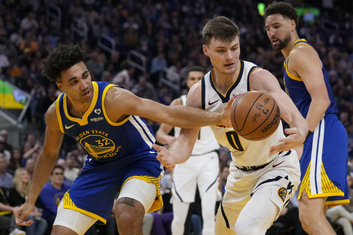 Golden State Warriors forward Trayce Jackson-Davis (L) and Denver Nuggets guard Christian Braun (0) compete for possession of the ball during the first half of an NBA basketball game in San Francisco on Feb. 25, 2024. (Godofredo A. Vásquez/AP Photo)