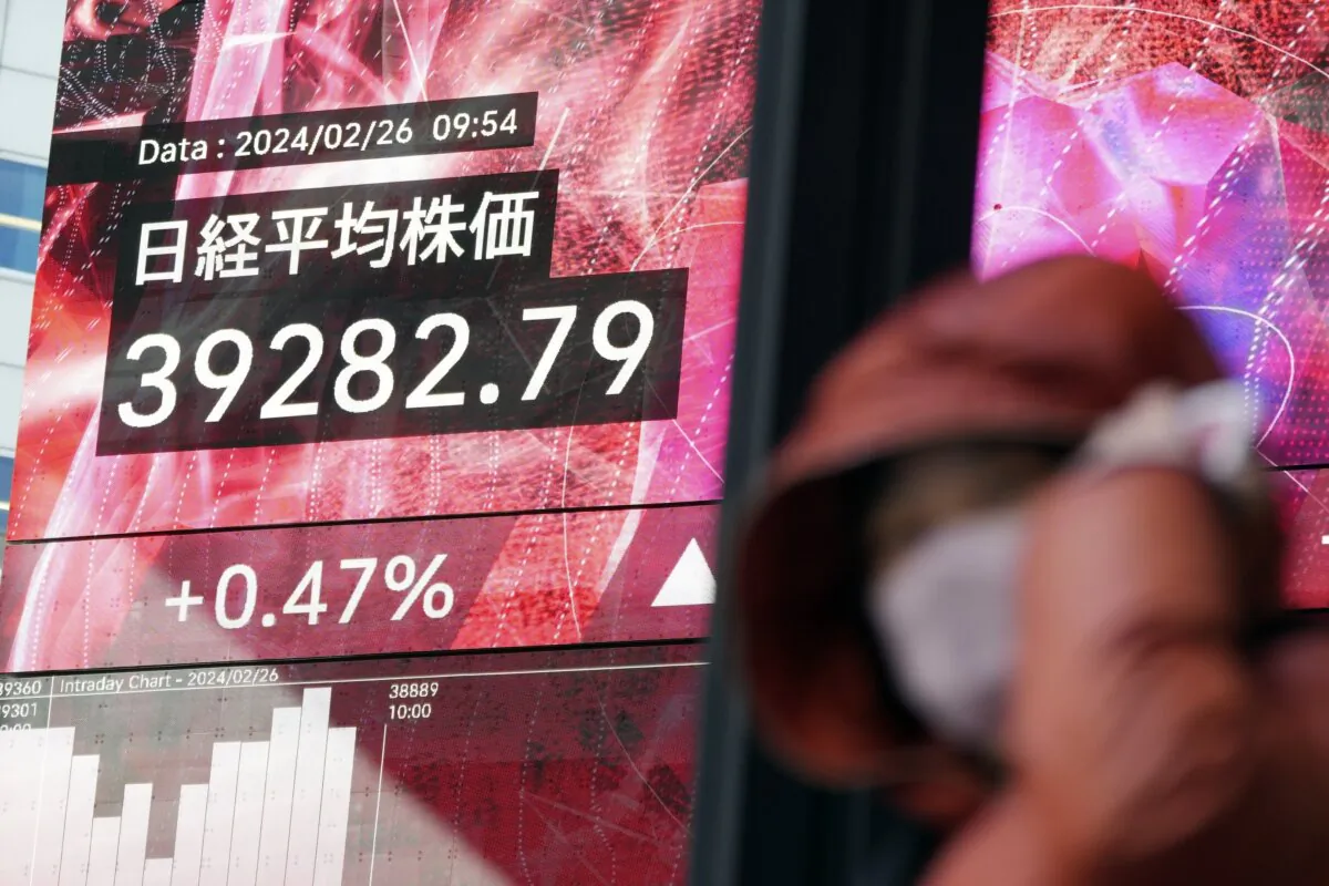 A person walks in front of an electronic stock board showing Japan's Nikkei 225 index at a securities firm in Tokyo on Feb. 26, 2024. (Eugene Hoshiko/AP Photo)