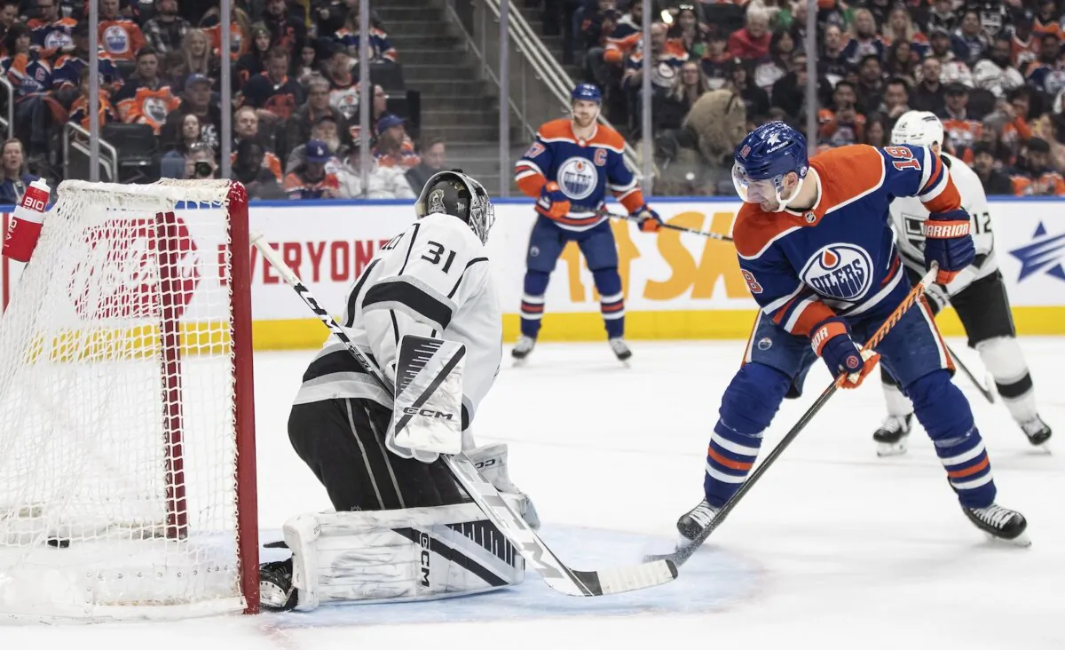 Edmonton Oilers' Zach Hyman (18) watches a tip-in by teammate Leon Draisaitl (not shown) go in past Los Angles Kings goalie David Rittich (31) during second-period NHL hockey game action in Edmonton, Alberta, on, Feb. 26, 2024. (Jason Franson/The Canadian Press via AP)
