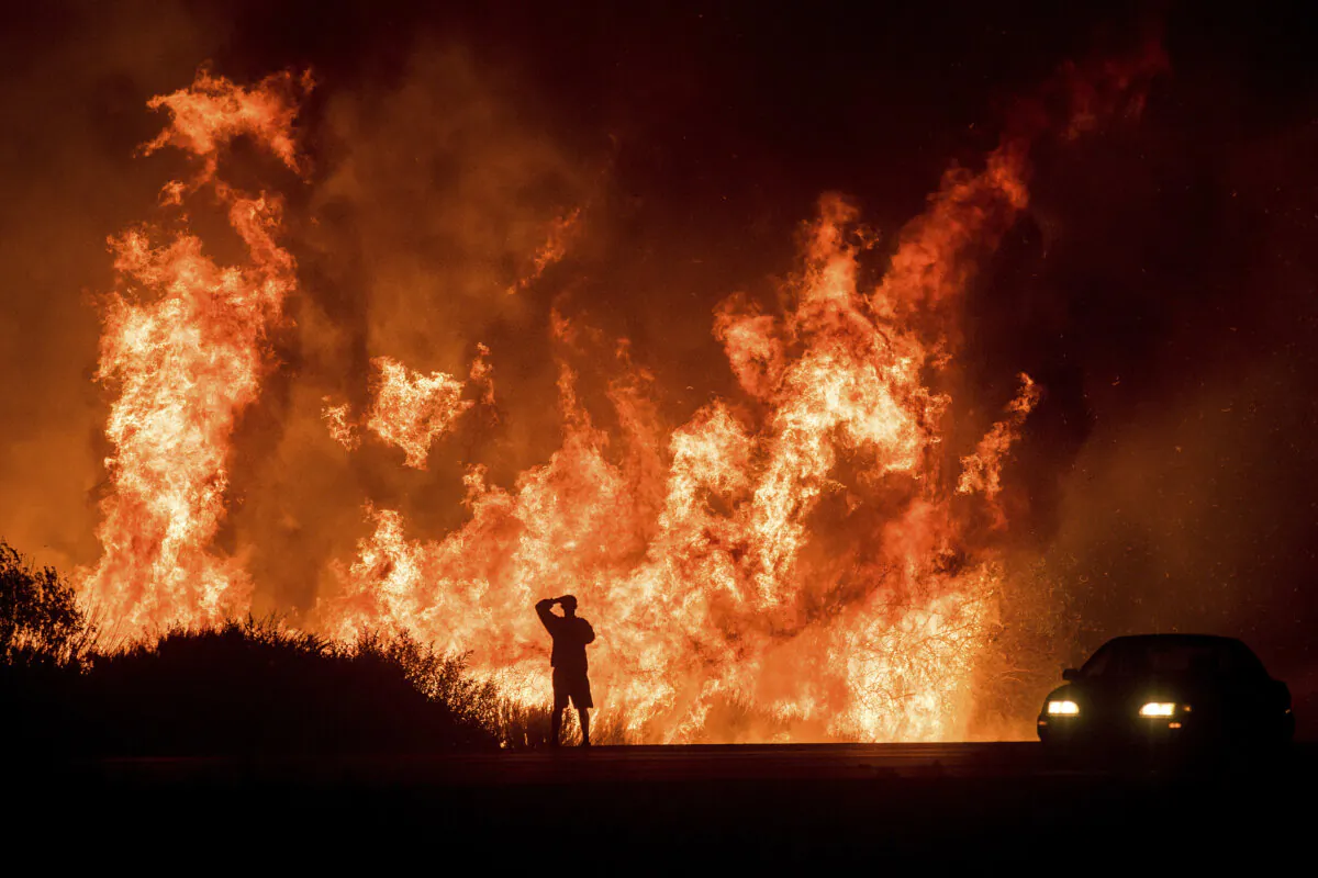A motorist on Highway 101 watches flames from the Thomas Fire leap above the roadway north of Ventura, Calif., on Dec. 6, 2017. (Noah Berger/AP Photo)