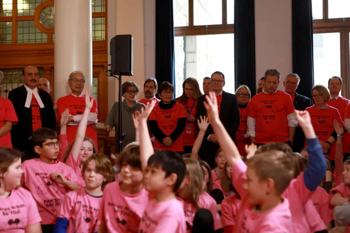 Ministers look on during Pink Shirt Day with students from South Park Elementary at the legislature in Victoria, Feb. 22, 2023. (The Canadian Press/Chad Hipolito)