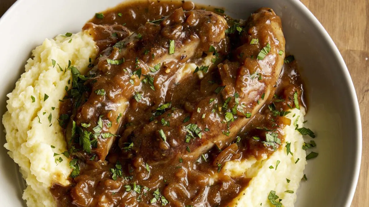 A mixture of Guinness, Dijon mustard, and onion doubles as a simmering sauce and a gravy for bratwurst sausages. (Elizabeth Fuller/TNS)