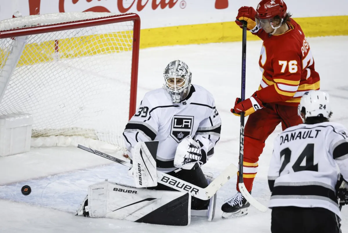 Los Angeles Kings goalie Cam Talbot (39) stops a shot from Calgary Flames forward Martin Pospisil (76) during the third period of an NHL hockey game in Calgary, Alberta, on Feb. 27, 2024. (Jeff McIntosh/The Canadian Press via AP) 