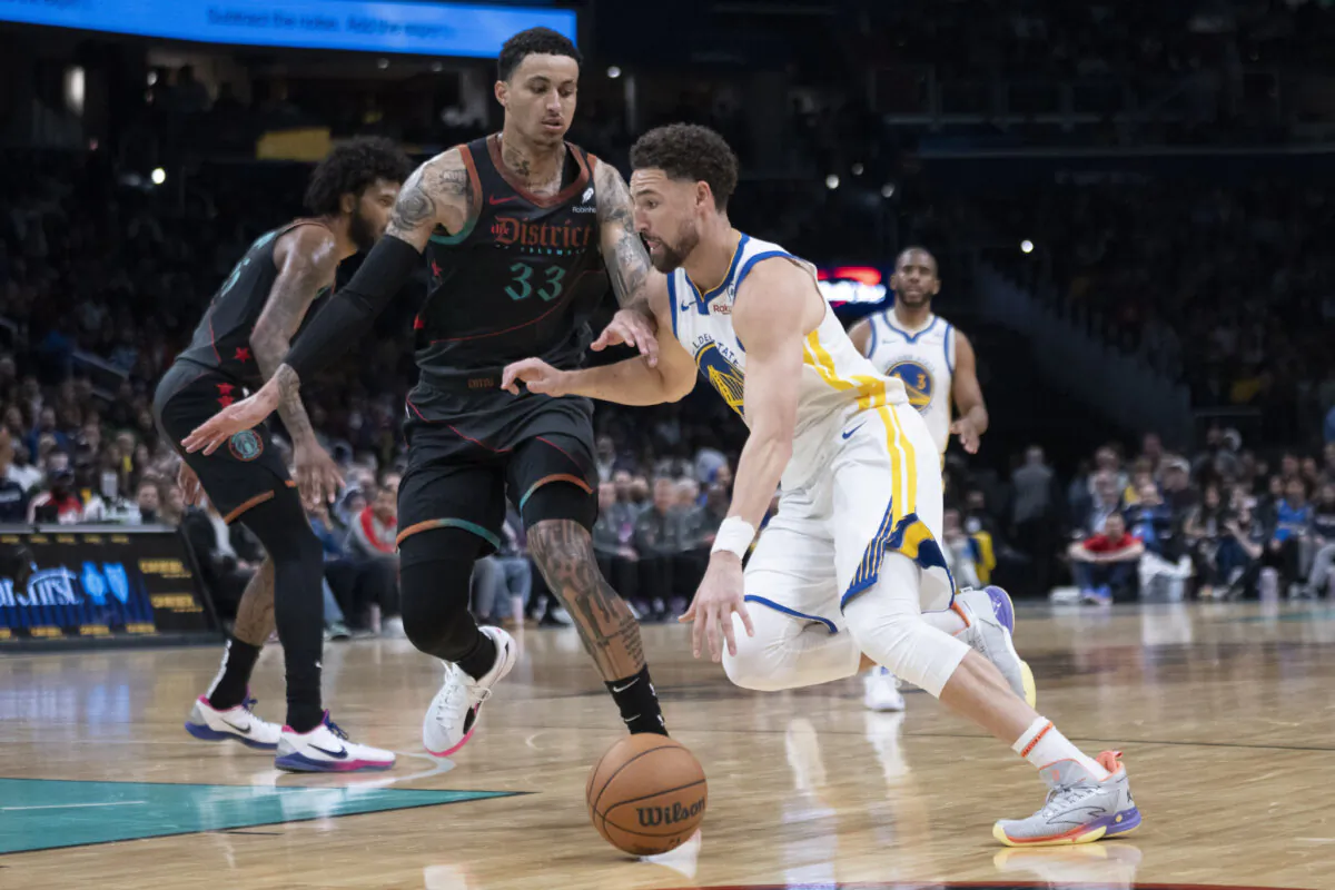 Golden State Warriors guard Klay Thompson (11) drives while Washington Wizards forward Kyle Kuzma (C), defends during the first half of an NBA basketball game in Washington on Feb. 27, 2024. (Manuel Balce Ceneta/AP Photo)