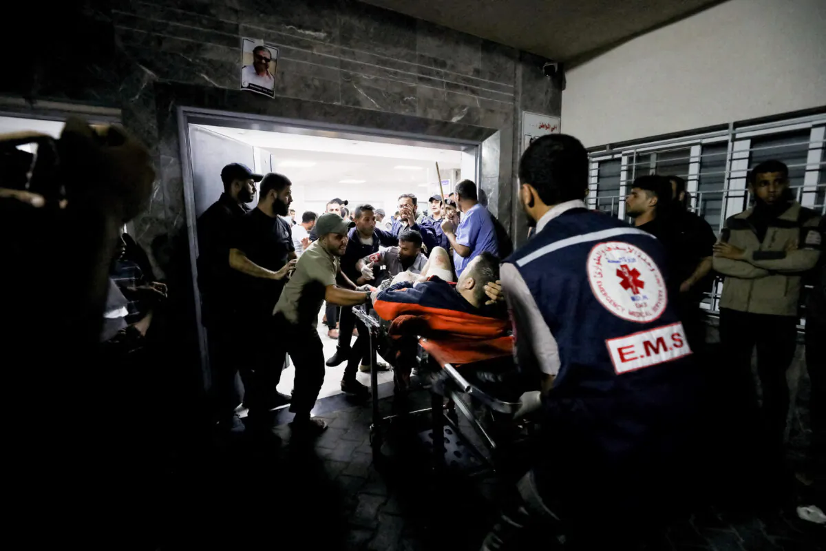 An injured person is assisted after an explosion in the courtyard of Al-Ahli hospital in Gaza, on Oct. 17, 2023. National Security Council analysis indicated the explosion was caused by an errant rocket from Islamic Jihad. The original global news agency caption for this photo read: "An injured person is assisted at Shifa Hospital after an air strike hit the nearby Al-Ahli Hospital, according to Gaza Health Ministry in Gaza City, Gaza Strip, on Oct. 17, 2023."(Mohammed Al-Masri/Reuters)